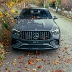 SUV Mercedes-Benz GLE 53 visto de frente em uma estrada cercada por folhagem de outono