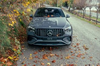 SUV Mercedes-Benz GLE 53 visto de frente em uma estrada cercada por folhagem de outono