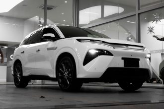 SUV elétrico branco exposto em um showroom moderno.