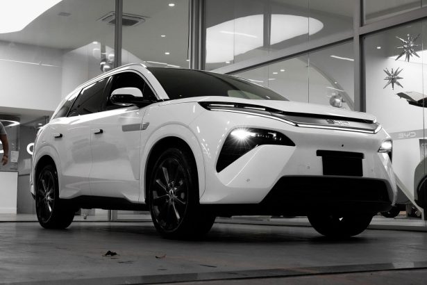 SUV elétrico branco exposto em um showroom moderno.