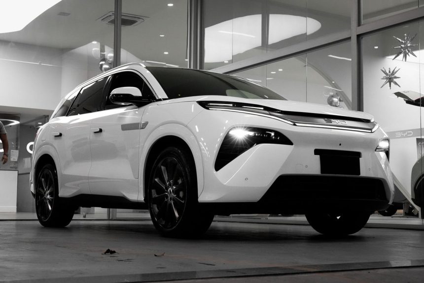SUV elétrico branco exposto em um showroom moderno.
