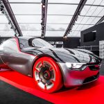 Carro-conceito futurista exposto em um salão automotivo, com desenho esportivo e linhas aerodinâmicas.
