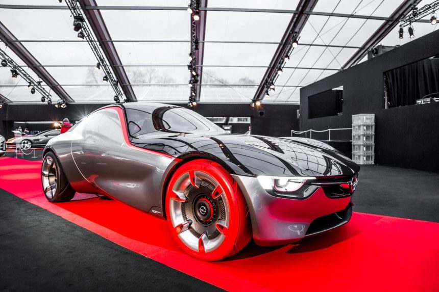 Carro-conceito futurista exposto em um salão automotivo, com desenho esportivo e linhas aerodinâmicas.