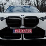 Veículo BMW visto de frente, estacionado ao ar livre, com placa ucraniana.