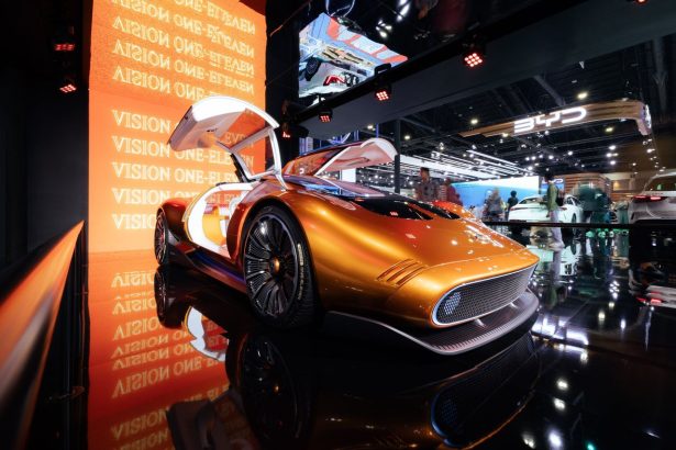 Carro-conceito futurista laranja exposto em um salão internacional do automóvel.