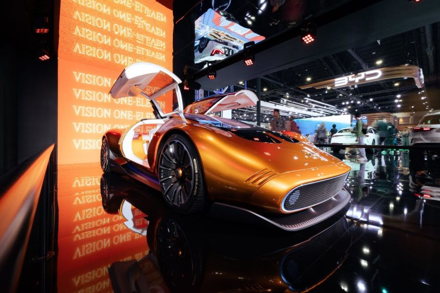 Carro-conceito futurista laranja exposto em um salão internacional do automóvel.