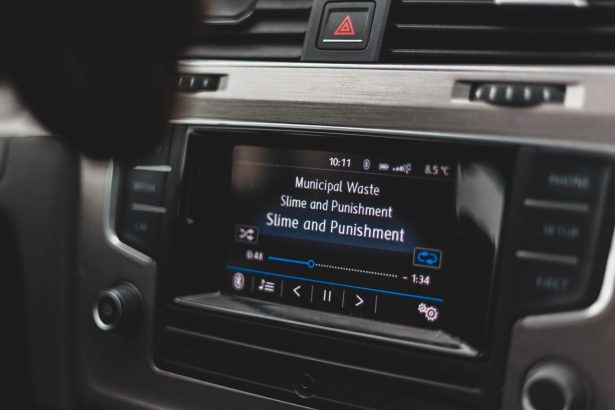 Tela multimídia de um carro exibindo uma interface de reprodução de música.