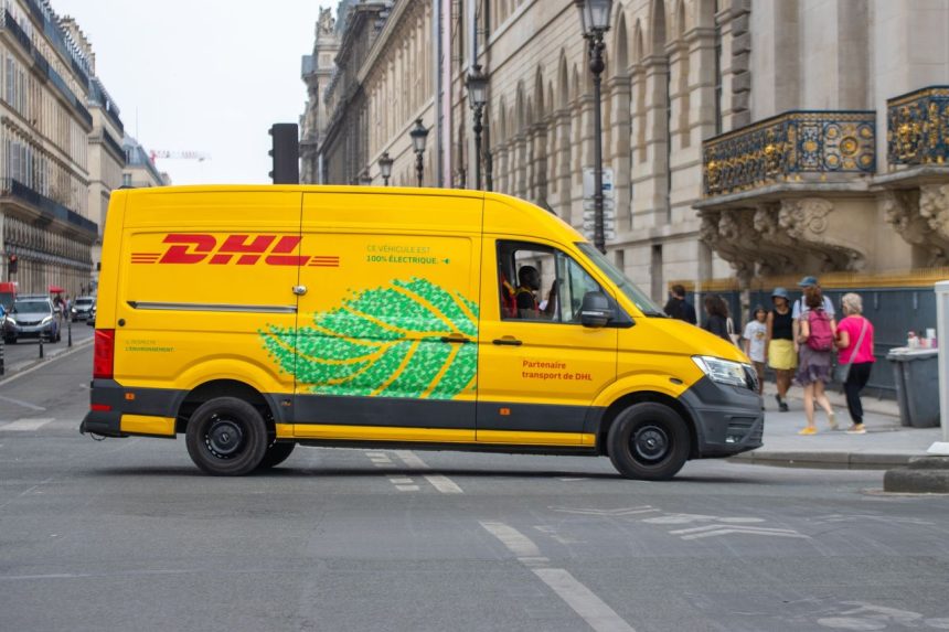 Van elétrica de entregas circulando por uma movimentada rua de Paris em um dia ensolarado.