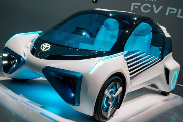 Carro-conceito azul exposto em uma mostra automotiva, visto de frente em um ambiente de exposição.