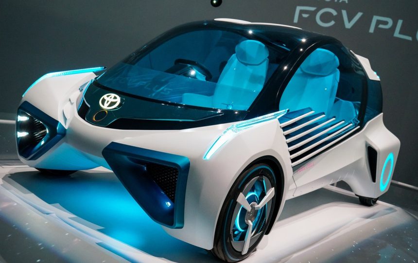 Carro-conceito azul exposto em uma mostra automotiva, visto de frente em um ambiente de exposição.
